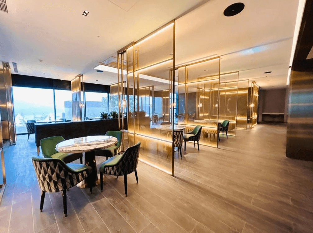 【台灣最貴飯店】漢來日月行館高雅時尚的公共空間或餐廳區，金屬與玻璃隔間搭配溫暖燈光設計，營造現代奢華氛圍，設有圓桌與舒適椅子，適合用餐或交誼使用。
