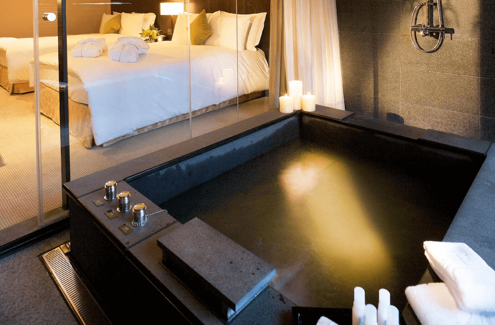 【蘇澳住宿】瓏山林蘇澳冷熱泉度假飯店的獨立冷熱雙泉湯池，搭配深色石材設計與燭光裝飾，玻璃隔間與房間相連，營造出高隱私感與放鬆療癒氛圍。