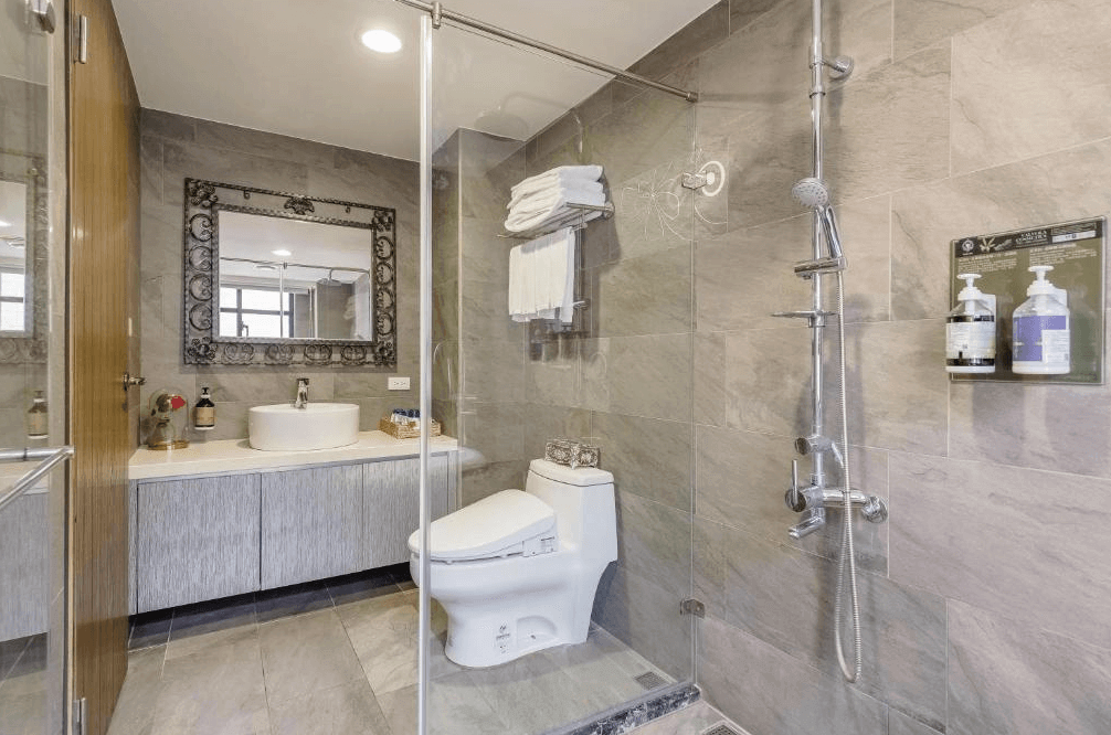 【五結住宿】米蘭穀堡的現代衛浴空間，配備乾濕分離淋浴間、免治馬桶與圓形洗手台，鏡框為歐式雕花鐵藝風格，整體清新且具有設計感。