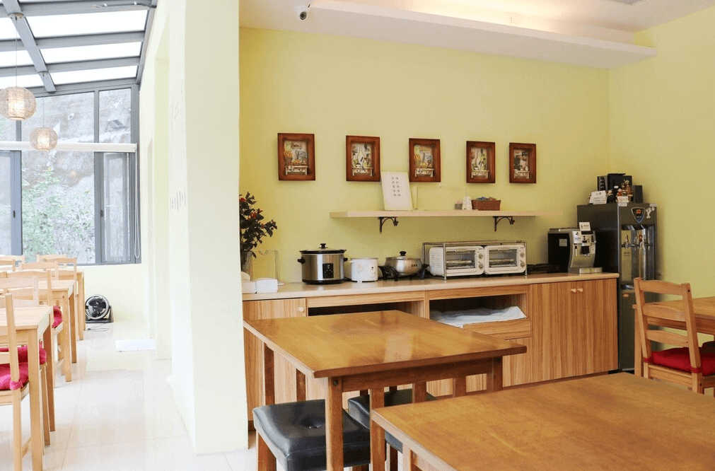 【關子嶺溫泉】“白河住宿”芳谷溫泉小棧明亮寬敞的早餐區，配有多組木質桌椅、自助式餐台，提供吐司機、熱水機、咖啡機與電鍋等設備。