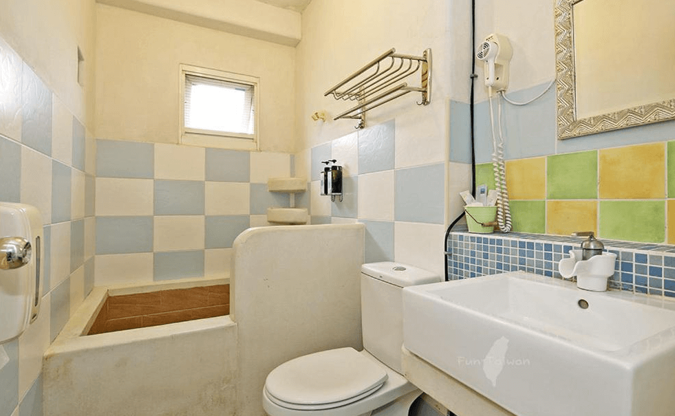 【蘇澳住宿】蕾米斯莊園的鄉村風浴室，搭配藍白相間的磁磚與馬卡龍色系牆面，設有半開放式浴缸、洗手台與馬桶，空間整潔舒適，備有基本盥洗用品。