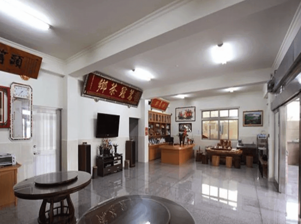 【瑞里民宿】詹德仁茶園民宿的交誼廳，內有茶藝桌、展示櫃與書畫裝飾，空間寬敞明亮，是住客休息與品茗的好地方。