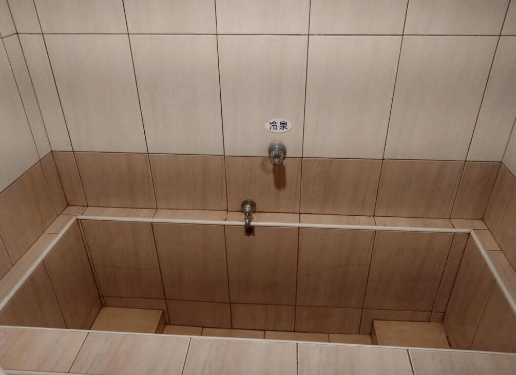 【蘇澳住宿】金華冷泉溫泉旅館內設冷泉浴池，方形空間以米色磁磚鋪設，牆面標示「冷泉」，簡潔實用，適合泡腳或體驗傳統冷泉文化。