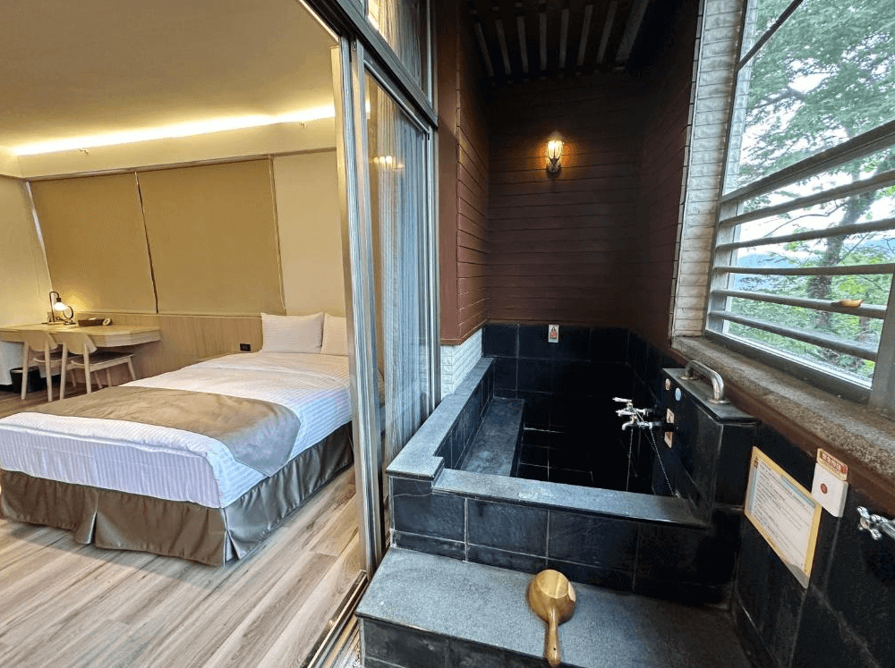 【關子嶺溫泉】關子嶺富野溫泉會館的客房專屬戶外黑色石砌湯池，設於陽台空間，可邊泡湯邊欣賞自然綠意景致，享受私人放鬆時光。