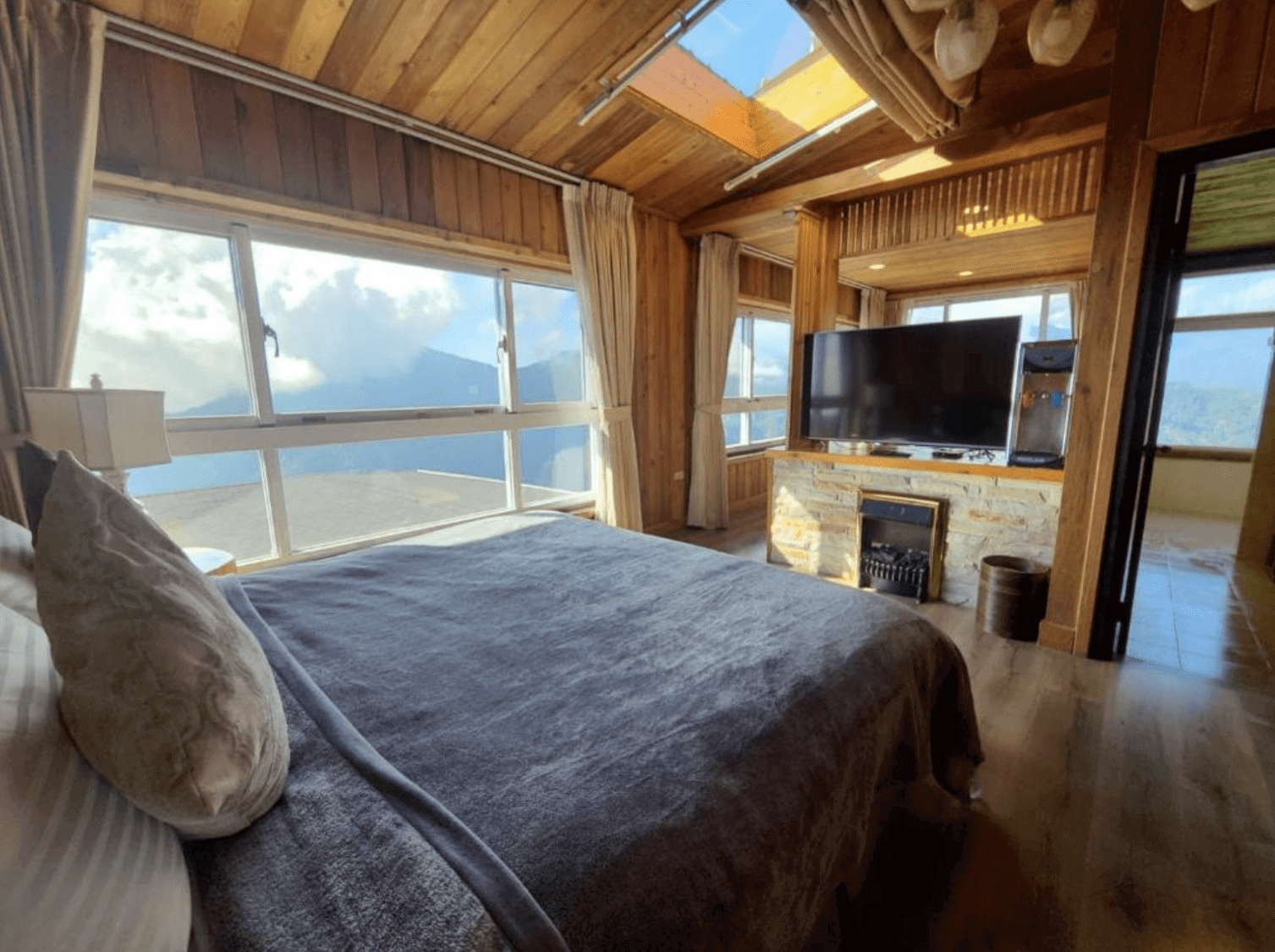 【清境農場住宿】雲頂渡假山莊，坐擁高山雲海美景的房間，木質設計搭配天窗與大片窗戶，床鋪面向電視與壁爐，自然採光充足，充滿溫暖與舒適感。