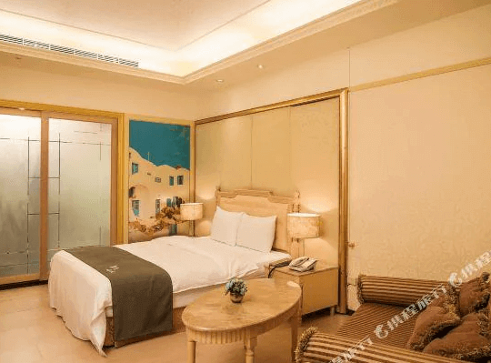 【谷關住宿】麗池山水溫泉會館的房間以米色與木質調為主，搭配古典風格的床頭板與家具，展現雅致氣息。床邊設有小圓木桌與沙發，牆上掛有地中海風格的壁畫，整體氛圍溫馨且具有異國情調。