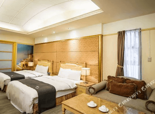 【谷關住宿】麗池山水溫泉會館的四人房設有兩張雙人床，搭配金色繃布床頭與木質傢俱，增添質感。沙發區舒適實用，適合家庭或朋友聚會休憩。柔和燈光營造溫暖氛圍，窗邊自然光透入，使空間更顯明亮。