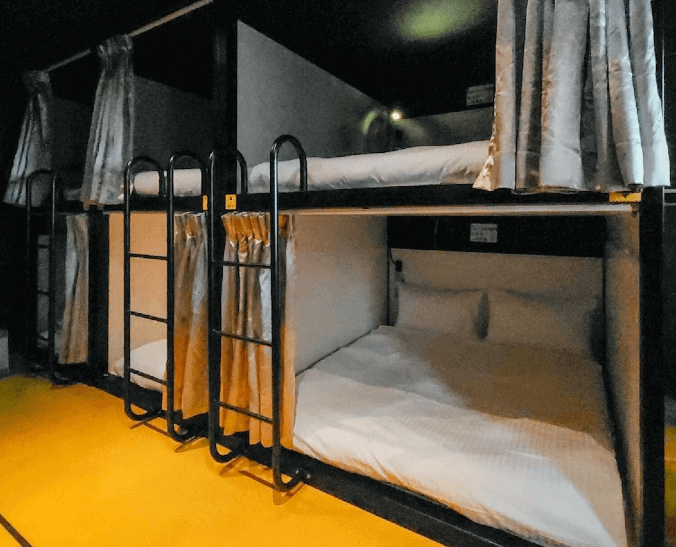 【台北車站青年旅館】Taipei Inn的房間內設有雙層膠囊床位，每個床位皆附有梯子與遮光窗簾，床位寬敞，床單潔白整齊，營造出隱私與舒適兼具的住宿環境。