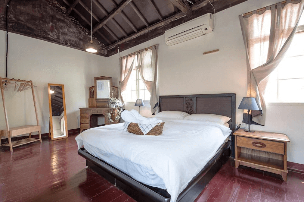 【左營住宿】丈引小院復古雙人房空間，傳統眷村風格的雙人房，配有大床與木質傢俱，斜屋頂與老窗框展現復古韻味，自然採光柔和溫馨。