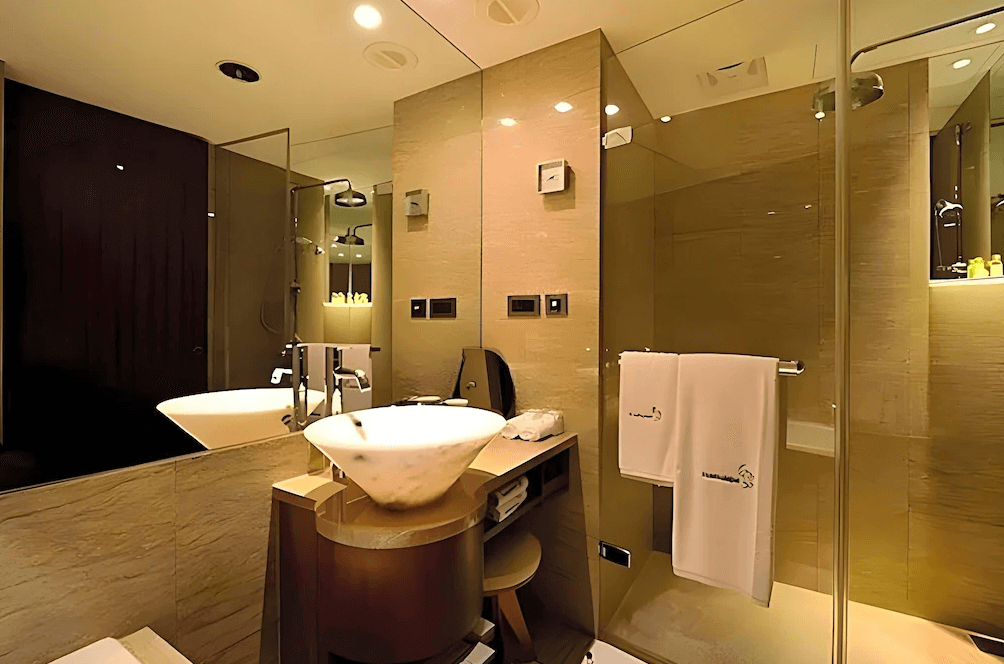 【台北小巨蛋住宿】台北商旅慶城館的衛浴空間，搭配洗手台與乾濕分離淋浴設備，採用大理石牆面與鏡面設計，整潔明亮。