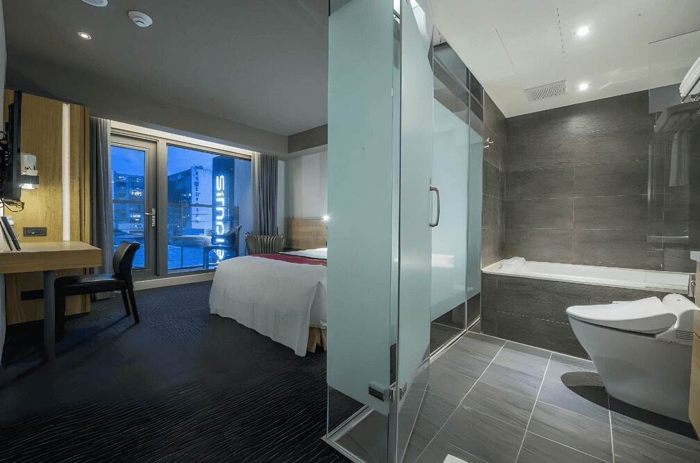 【台北小巨蛋住宿】台北馥華商旅敦北館的套房，內含乾濕分離衛浴與浴缸，搭配玻璃隔間與大面採光，展現都會簡潔設計感。