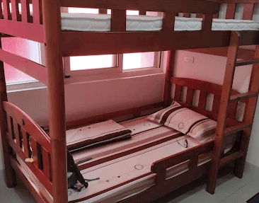 【左營住宿】國泰旅社紅光照明背包床位，靠窗的實木上下舖床位，採用自然木色設計，搭配紅色窗簾採光，床鋪配有基本床組與個人閱讀燈。