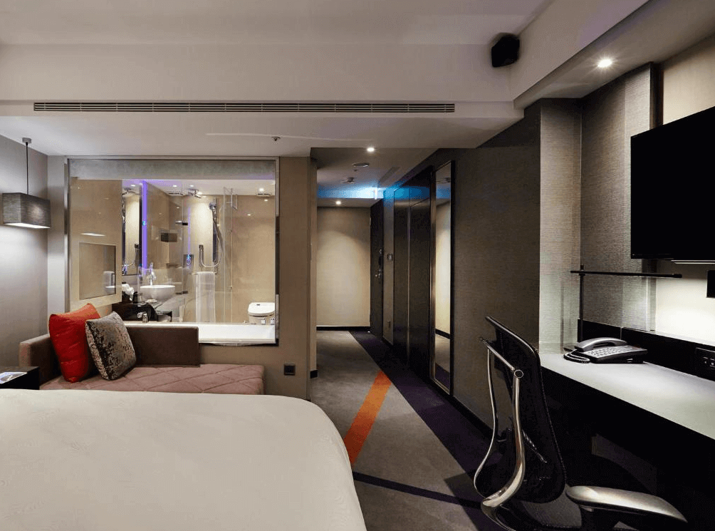 【台北小巨蛋住宿】天閣酒店 台北復興的商務雙人房，設有沙發區與玻璃隔間浴室，空間機能完整，兼具舒適與實用。