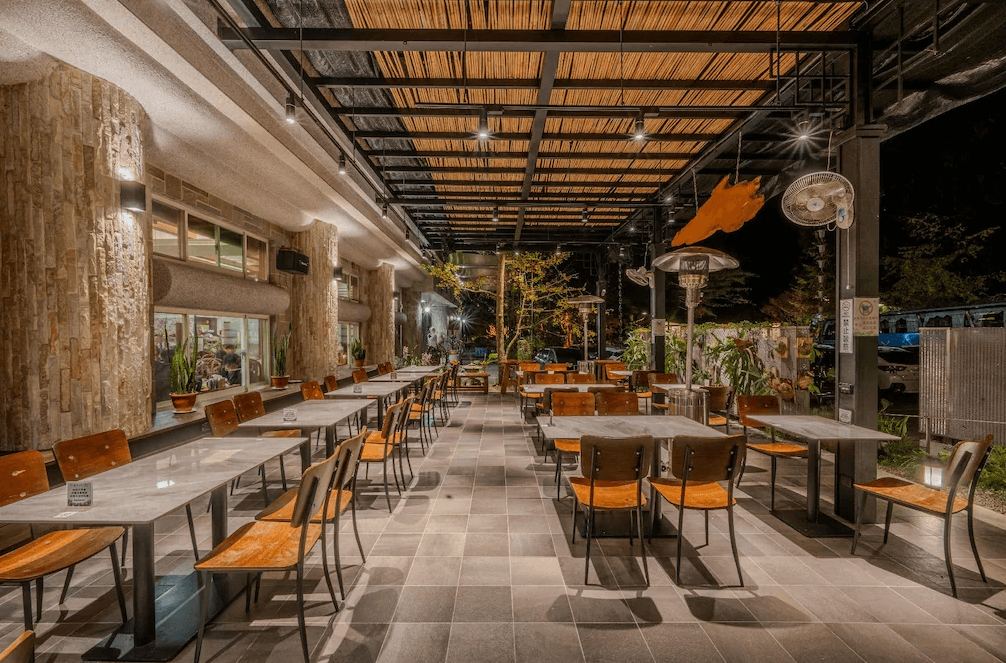 【杉林溪住宿】孟宗山莊大飯店的戶外用餐區，設有多張長桌與暖爐，加上石材與木質裝飾營造自然休閒風格。