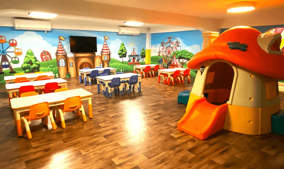 【杉林溪住宿】明山森林會舘的兒童遊戲空間，設有滑梯造型小屋、童趣彩色椅桌與繽紛牆面插畫，營造如童話世界般的歡樂環境。