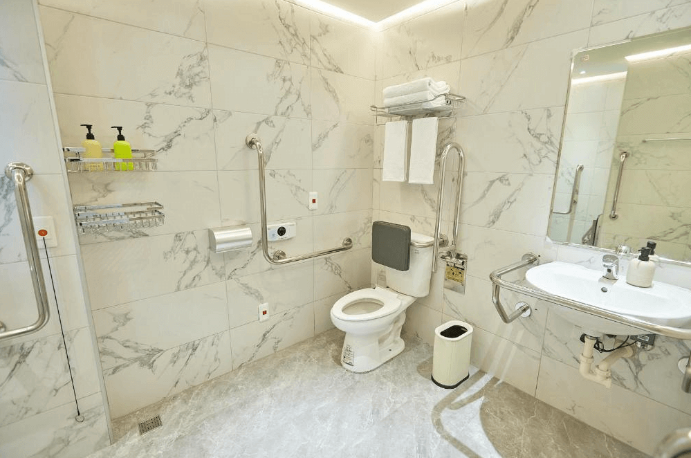 【左營住宿】星澄風旅無障礙友善浴室設施，浴室空間寬敞，配有無障礙扶手、緊急鈴與防滑地磚，整體以大理石紋磁磚裝潢，兼具安全與美觀。