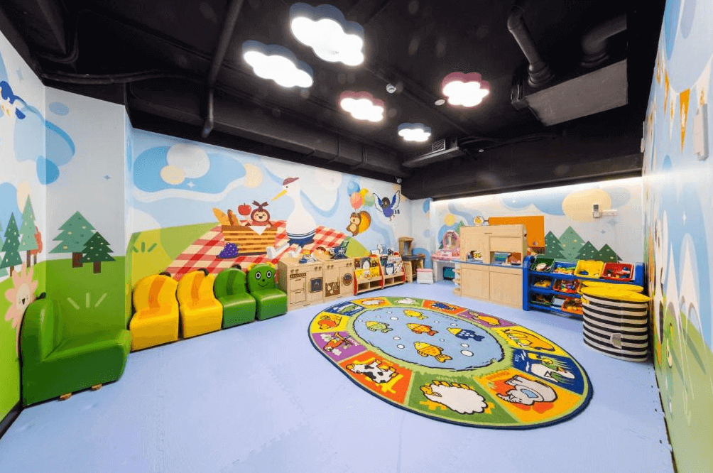 【龍潭住宿】桃園高爾夫俱樂部 ‧ 悅華大酒店，以森林野餐為主題的室內親子遊戲空間，牆面繪有動物與樹木彩繪，地板鋪有安全軟墊與色彩繽紛的圖案地毯，擺設多款玩具與遊戲設施，營造出友善安全又充滿童趣的親子環境。
