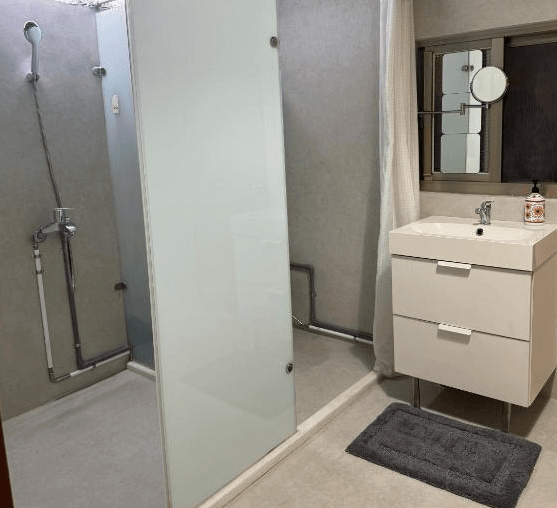 【左營住宿】海軍官邸四號院現代衛浴設備，浴室設有乾濕分離設計，使用霧面玻璃隔間，搭配白色洗手台與鏡櫃，整體風格現代簡約且整潔。