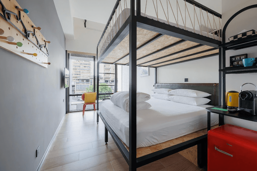 【台北寵物友善住宿】瀚寓夏天，設有上下舖設計的家庭房型，下層為雙人床，上層為單人床，並配有兒童友善裝飾與亮色系傢俱，適合親子入住，窗邊可眺望市區景色，備有咖啡機與飲水壺。