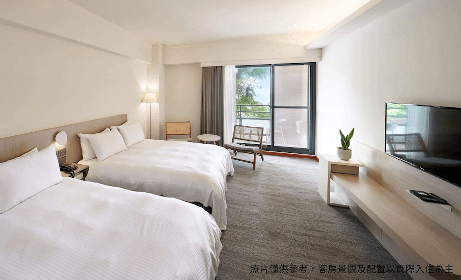 【龍潭住宿】石門水庫福華渡假飯店的雙床房，設有兩張舒適單人床，大片落地窗引入自然採光與綠意景觀，室內以米白與木質調為主，搭配溫暖立燈與小圓桌椅，營造清新又放鬆的住宿氛圍。