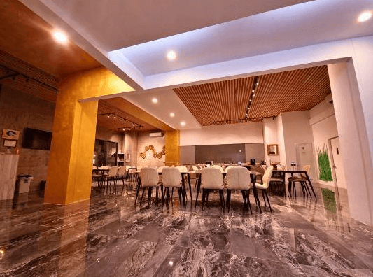 【綠島住宿】綠島House16的寬敞用餐大廳，地板鋪設大理石磁磚，搭配現代吊燈與木格天花設計，提供多組座位，適合團體聚餐與活動。