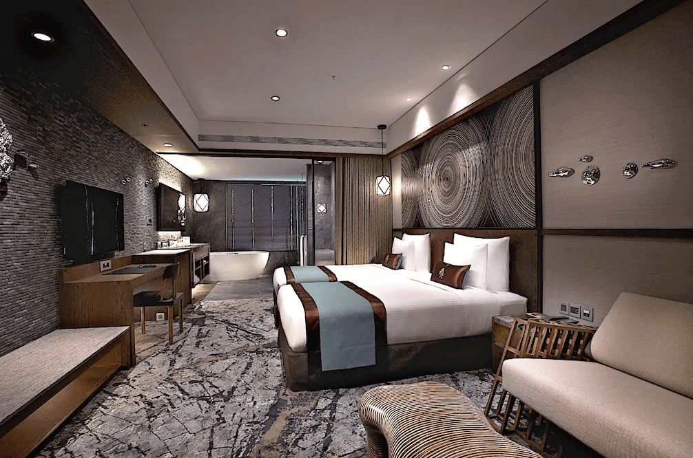 【台北小巨蛋住宿】阿樹國際旅店的雙人房，融合深色木質與石紋地毯，附設開放式浴缸與舒適沙發，營造沉穩質感空間。