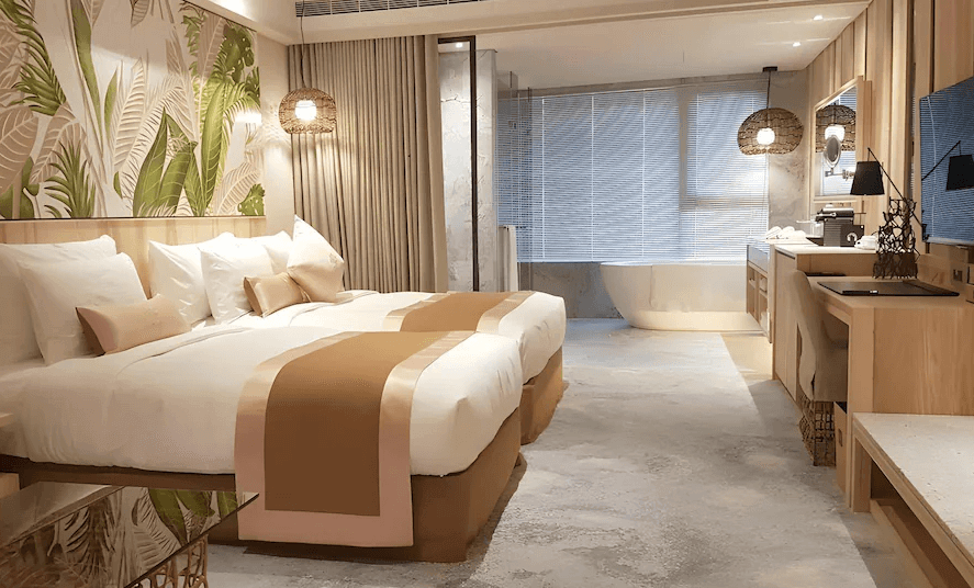 【台北小巨蛋住宿】阿樹國際旅店的雙人房，以淺木色調與綠意植栽牆面為主題，搭配開放式衛浴與圓形浴缸，明亮溫馨。