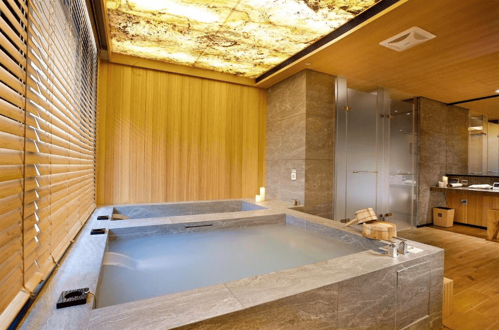 【台北小巨蛋住宿】阿樹國際旅店的日式風格雙人湯屋，搭配大片木質牆面與石材浴池，提供私密放鬆空間與溫泉體驗。
