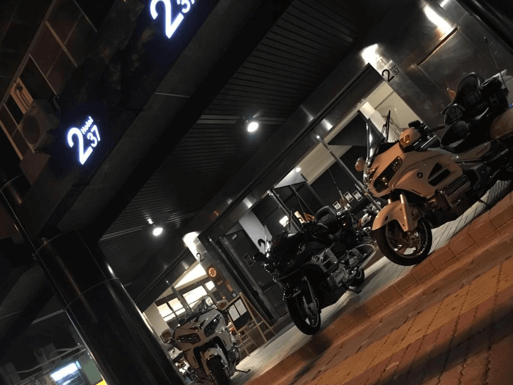 【高雄寵物友善住宿】237重機主題旅店的旅店外觀，招牌寫有「2 Hotel 37」，門口停放數輛重機，營造出帥氣摩登的重機主題氛圍，極具辨識度與特色。