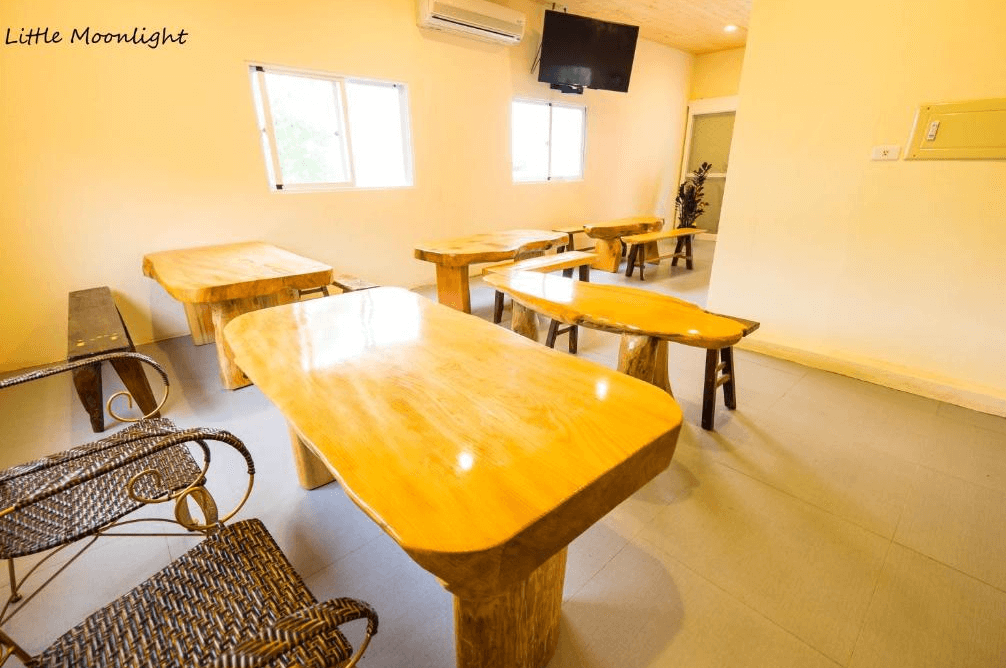 【台東成功住宿】台東「三仙台小月光民宿」用餐空間，以原木桌椅搭配編藤椅子，整體空間簡潔寬敞，採光明亮，是享用早餐或悠閒聊天的理想場域。