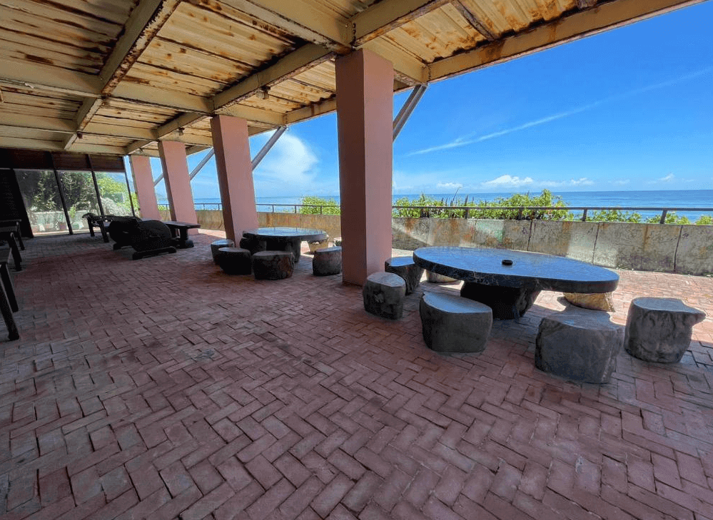 【豐濱住宿】來去海邊玉石咖啡民宿館，戶外區設有遮陽棚下的圓形與長方形石桌椅，空間寬敞，適合團體聚會或靜靜欣賞太平洋海景與藍天白雲，是午後納涼的好去處。