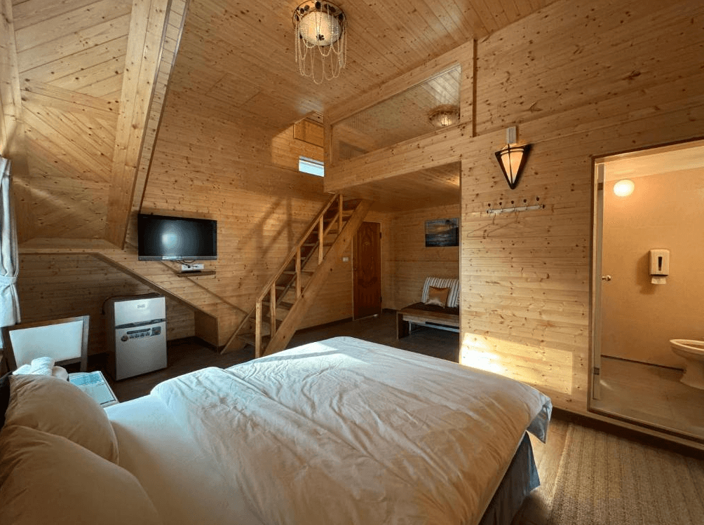 【長濱住宿】台東跑者之家民宿木屋樓中樓房型，全室以原木裝潢打造溫暖感，設有電視、小冰箱、樓梯通往閣樓空間，附獨立衛浴。