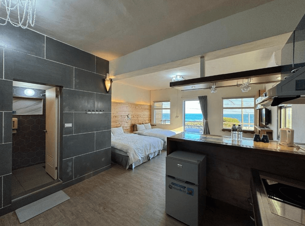 【長濱住宿】台東跑者之家民宿海景房型，設有兩張雙人床與開放式廚房，大片窗戶可遠眺藍色海景，並附現代化衛浴設備。