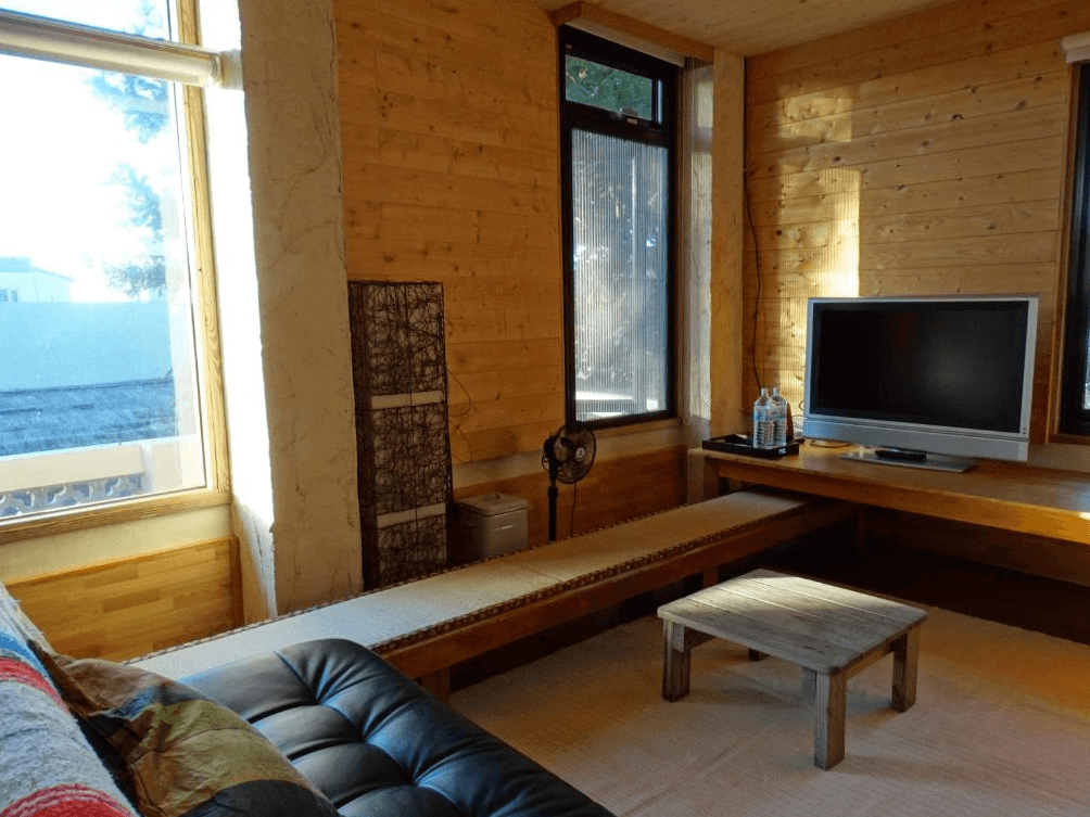 【台東成功住宿】台東「馬可樓民宿」公共客廳區域，採用溫暖的木質裝潢，設有簡約實用的家具，包括小茶几及電視，整體空間寧靜舒適，適合旅客休息交流或放鬆享受陽光。