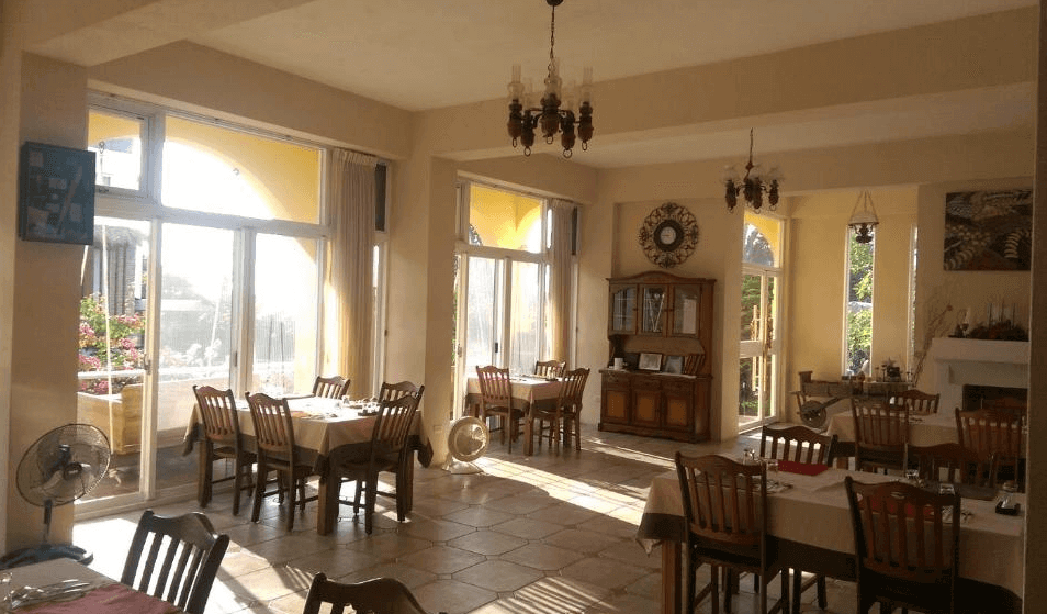 【台東成功住宿】台東「馬可樓民宿」餐廳空間內景，設計明亮寬敞，配有大型落地窗戶可引入充足自然光線，餐桌椅整齊排列，環境優雅舒適，提供溫馨自在的用餐氛圍。