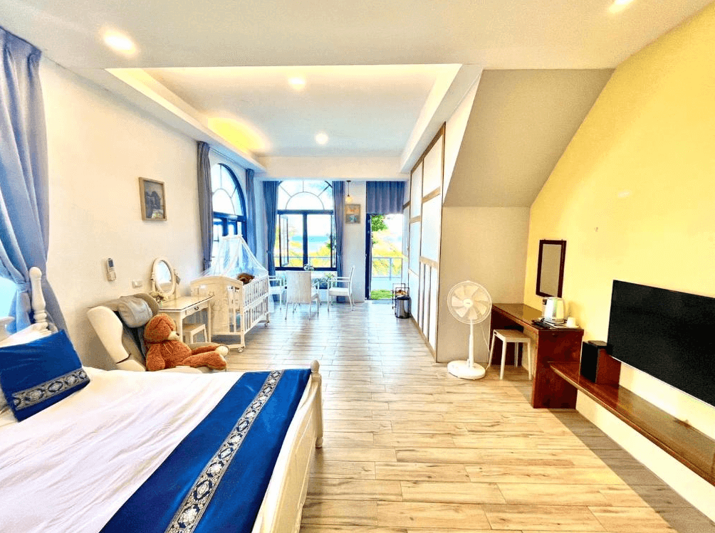 【豐濱住宿】太平洋渡假村的親子房型空間寬敞，配有舒適雙人床、嬰兒床、按摩椅與大泰迪熊，窗外可眺望湛藍海景，整體設計溫馨明亮，適合親子同住的度假選擇。