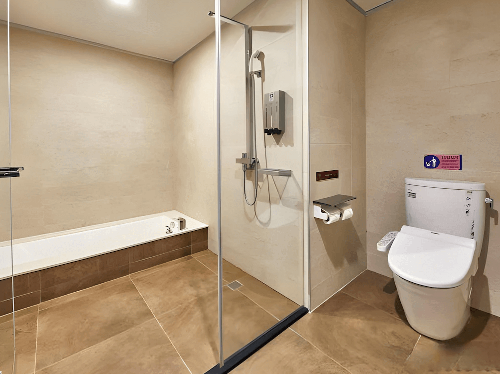 【桃園機場住宿】富立登國際大飯店的衛浴空間，設有乾濕分離淋浴區、浴缸與免治馬桶，整體以米色調為主，簡潔舒適。