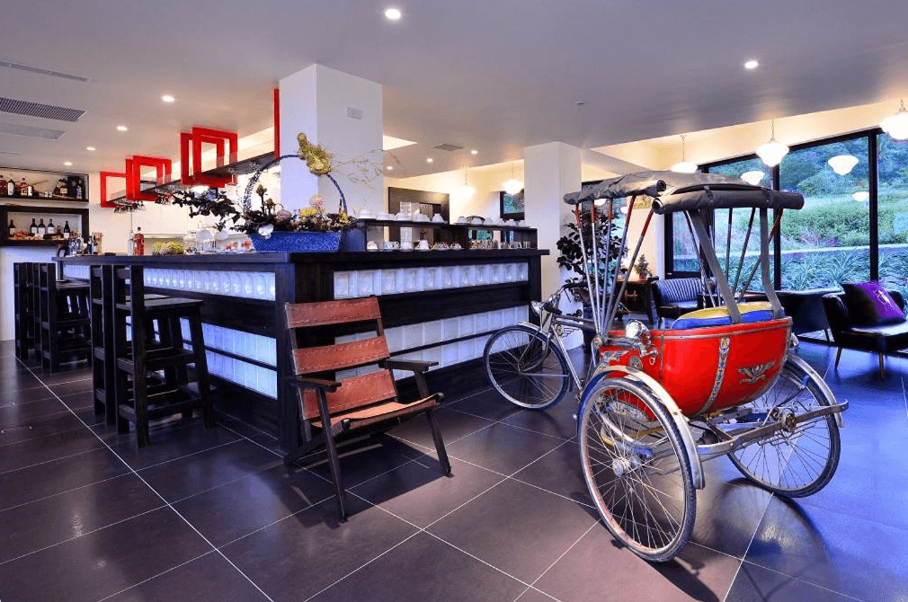 【台東成功住宿】台東「小馬日光涵館」大廳休憩區，融合現代與復古元素，中央設有吧台與懷舊人力三輪車裝飾，環境明亮整潔，氣氛溫馨別緻。