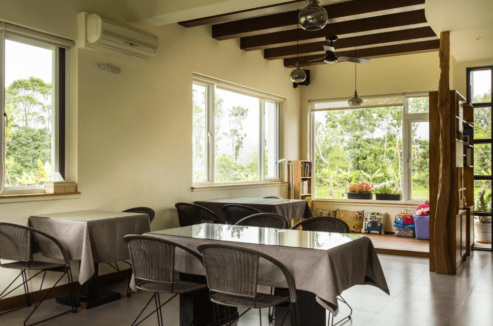 【關山住宿】弋式風莊園民宿的用餐區，空間寬敞明亮，擺設多組餐桌椅，窗邊設有玩具與童趣抱枕，適合親子家庭入住與用餐。