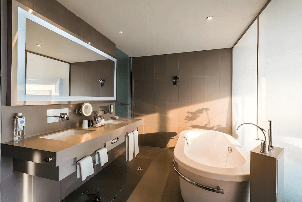 【桃園機場住宿】桃園國際機場凱悅酒店的高級浴室，配置有現代化雙洗手台、嵌入式燈鏡與獨立浴缸，空間寬敞且設計簡約時尚。