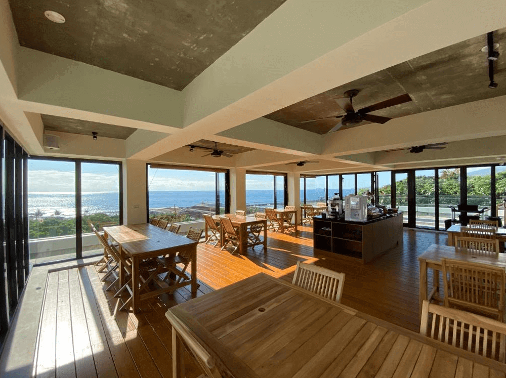 【長濱住宿】海Villa 胆曼會館頂樓景觀餐廳，大片落地窗環繞可俯瞰蔚藍海景，木質地板與桌椅營造開放舒適的用餐空間，配備自助咖啡吧。