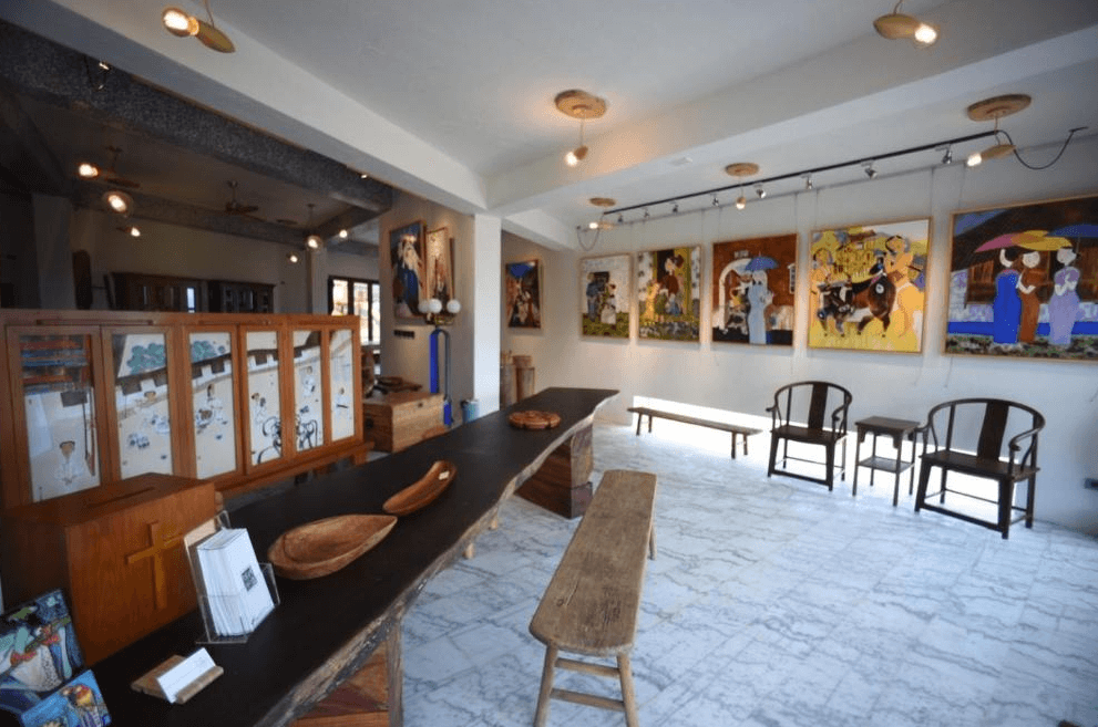 【東河住宿】石一方民宿藝文接待區，牆上掛滿畫作，空間結合藝廊與自然木作風格