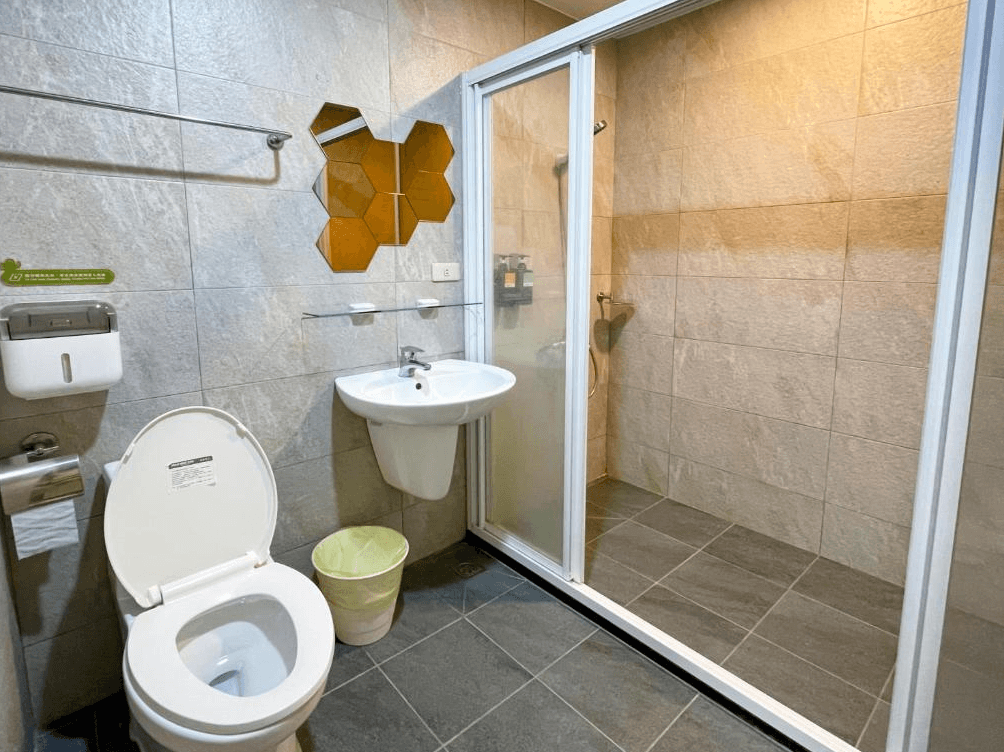 【苗栗包棟民宿】福田瓦舍 Villa的現代簡約風格浴室，灰色石紋磁磚搭配乾濕分離設計，設有洗手台、馬桶與玻璃拉門淋浴間，清潔舒適。