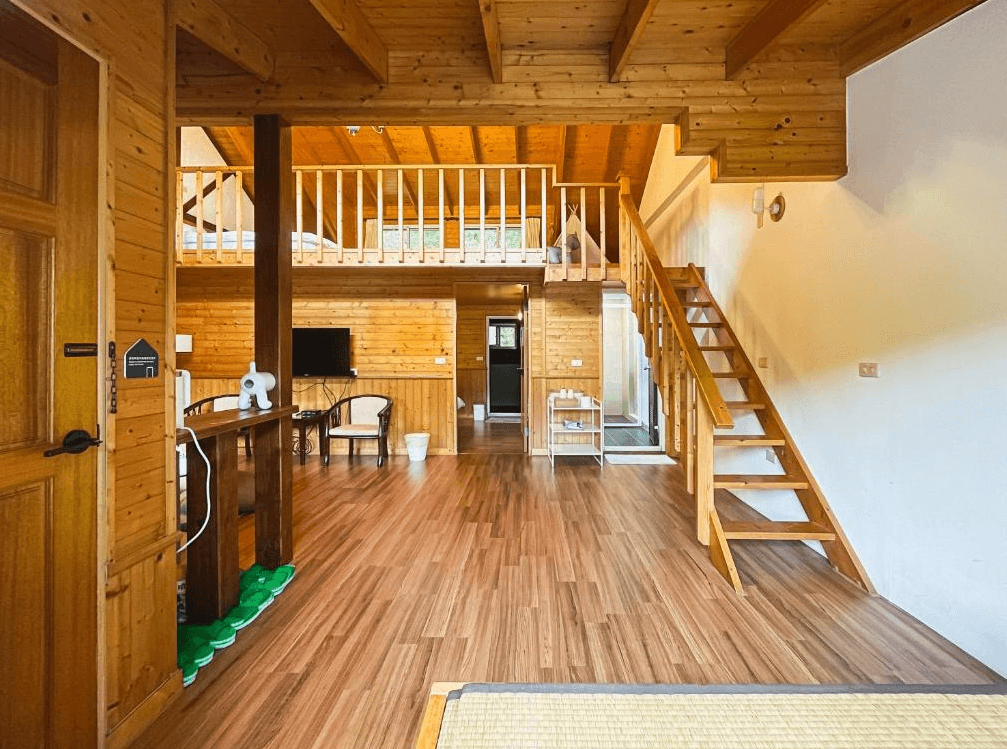 【苗栗包棟民宿】福田瓦舍 Villa木質建材打造的樓中樓空間，挑高設計感十足，配有電視、小沙發、樓梯通往閣樓，整體風格自然清新，適合多人住宿放鬆。