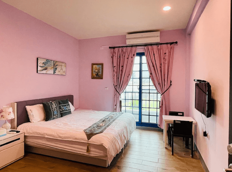 【關山住宿】稻香田園民宿的粉色雙人房，房內採柔和粉色牆面與花紋窗簾，營造溫馨浪漫氛圍，適合情侶或小家庭入住。