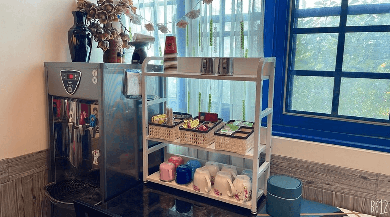 【關山住宿】稻香田園民宿的共用茶水區，備有熱水機、茶包、咖啡、杯具與即食點心，供住客自助取用，窗外自然光透入，明亮又便利。