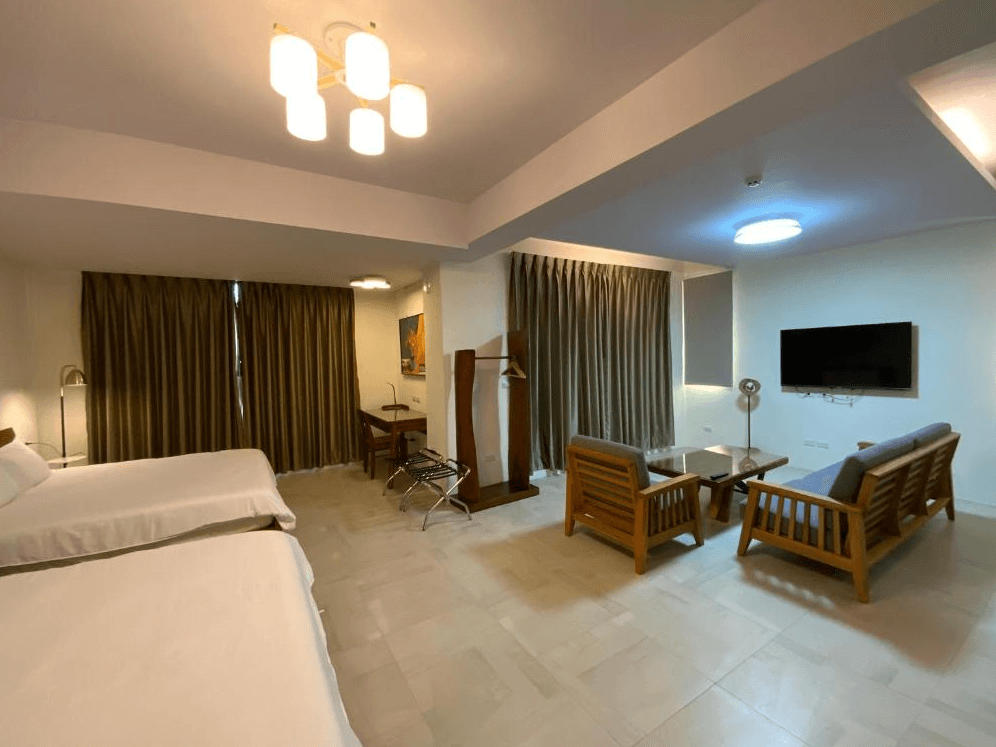 【長濱住宿】米粒教育家家庭房空間寬敞，除了兩張雙人床外，另設有木質沙發區與平面電視，適合親子或朋友團體共聚時光。