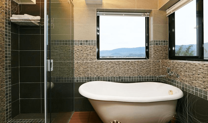 【關山住宿】纏民宿 x Remindful 的浴室空間，設有獨立復古浴缸與乾濕分離淋浴間，大片窗戶可眺望遠方山景，泡澡同時享受大自然療癒氛圍。