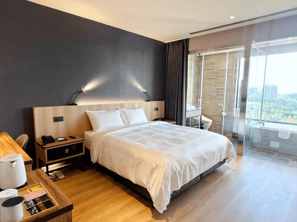 【桃園機場住宿】"桃園機場住宿精選示意圖"艾爾芙公園行旅的景觀房，搭配深色牆面與玻璃隔間衛浴設計，享有高樓層窗景與自然採光，適合情侶或商務旅客。