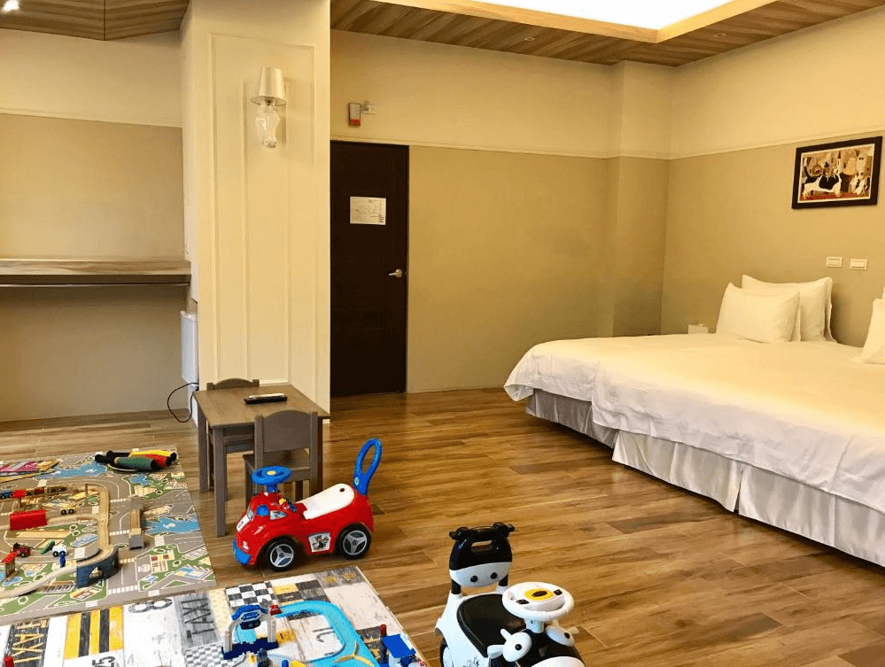【關山住宿】茶田關舍民宿的親子四人房，配有兩張大床、木地板，以及兒童玩具區和遊戲墊，是親子入住的理想選擇。